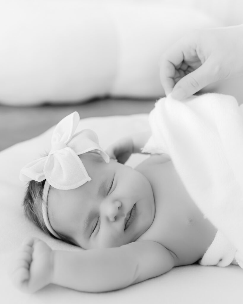 Newborn baby sleeps on white blanket during her studio newborn session with minneapolis newborn photographer, Angela Watts