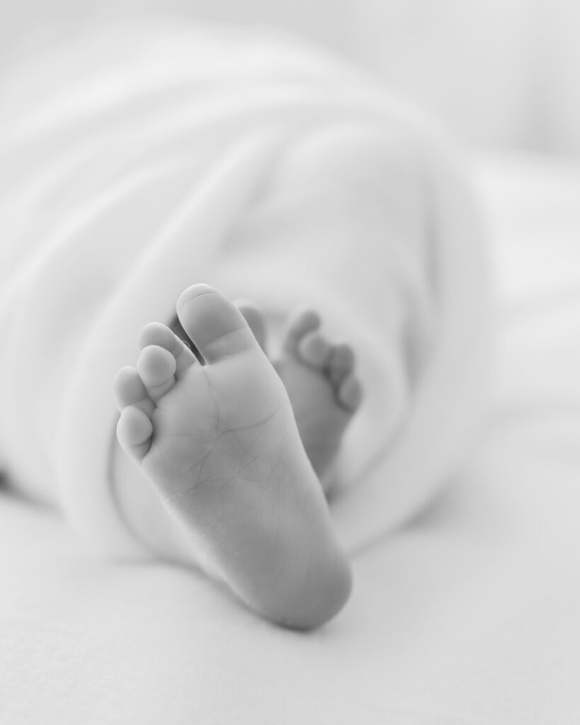 Newborn baby sleeps on white blanket during her studio newborn session with minneapolis newborn photographer, Angela Watts