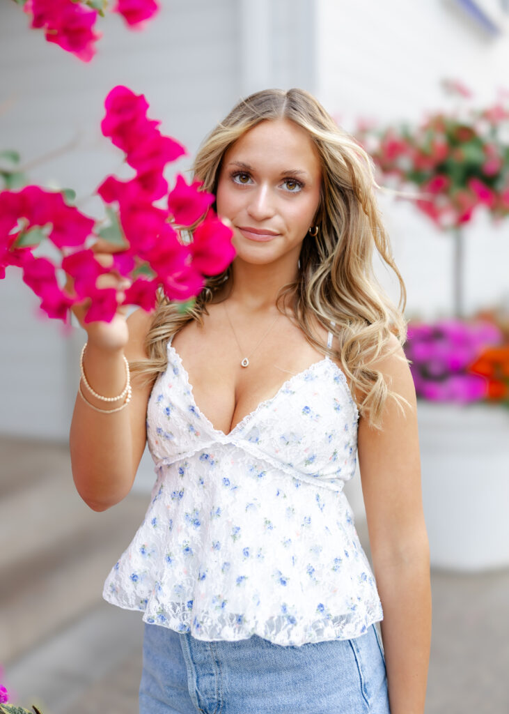 Girl in white tank and denim skirt poses downtown Wayzata for her wayzata senior pictures with angela watts photography