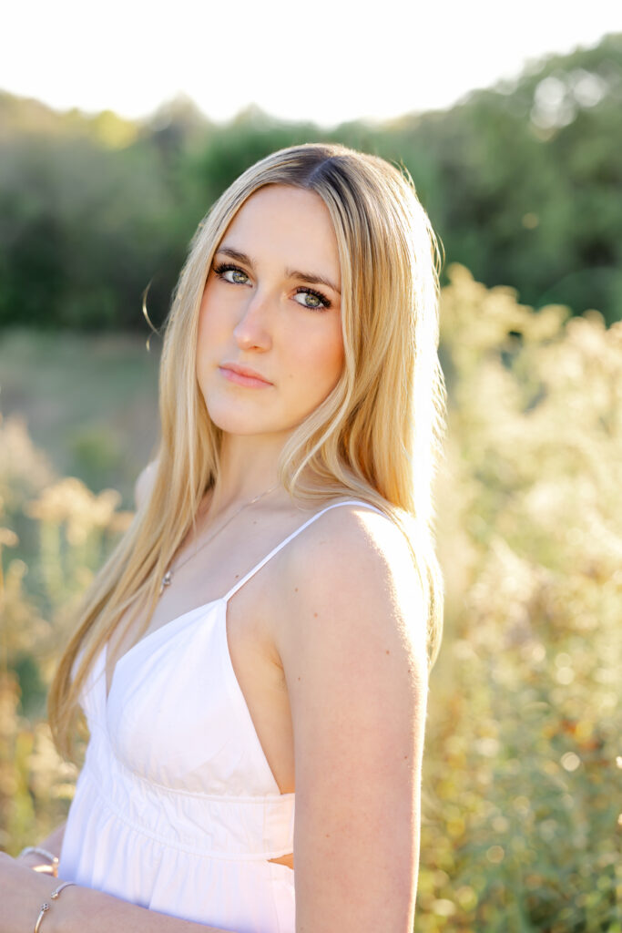 girl in white dress poses at longfellow gardens for her minneapolis senior photos with angela watts photography