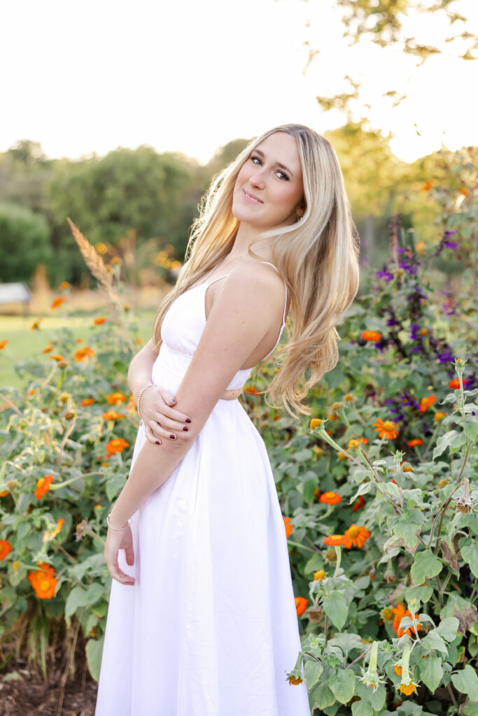 girl in white dress poses at longfellow gardens for her minneapolis senior photos with angela watts photography