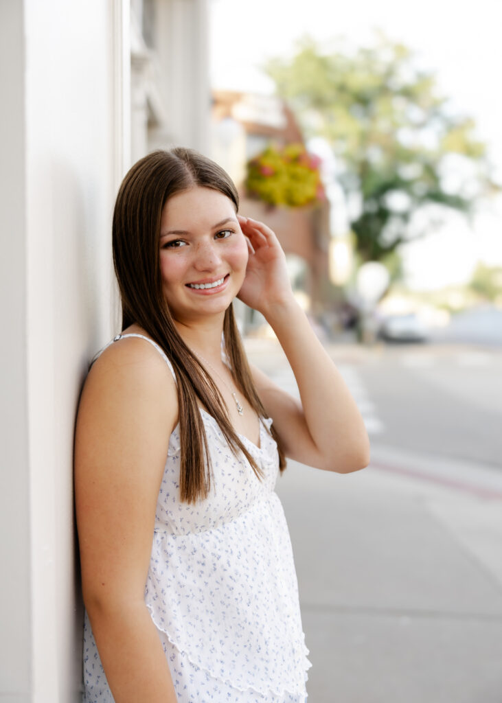 Girl in jeans and white tank takes her eden prairie senior photos downtown excelsior with senior photographer angela watts photography