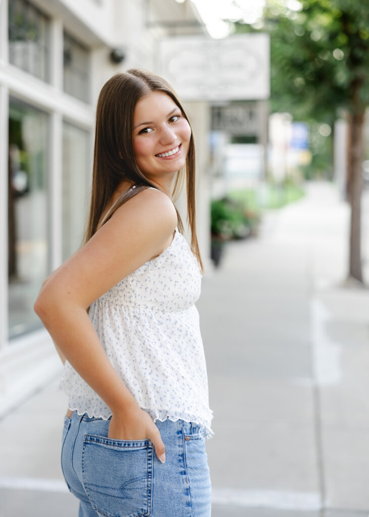 Girl in jeans and white tank takes her eden prairie senior photos downtown excelsior with senior photographer angela watts photography