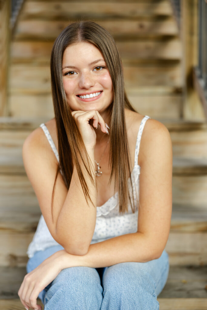 Girl in jeans and white tank takes her eden prairie senior photos downtown excelsior with senior photographer angela watts photography