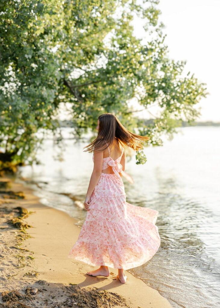 Girl runs along Excelsior beach in white and pink flowy dress for her eden prairie senior pictures with senior photographer angela watts photography.