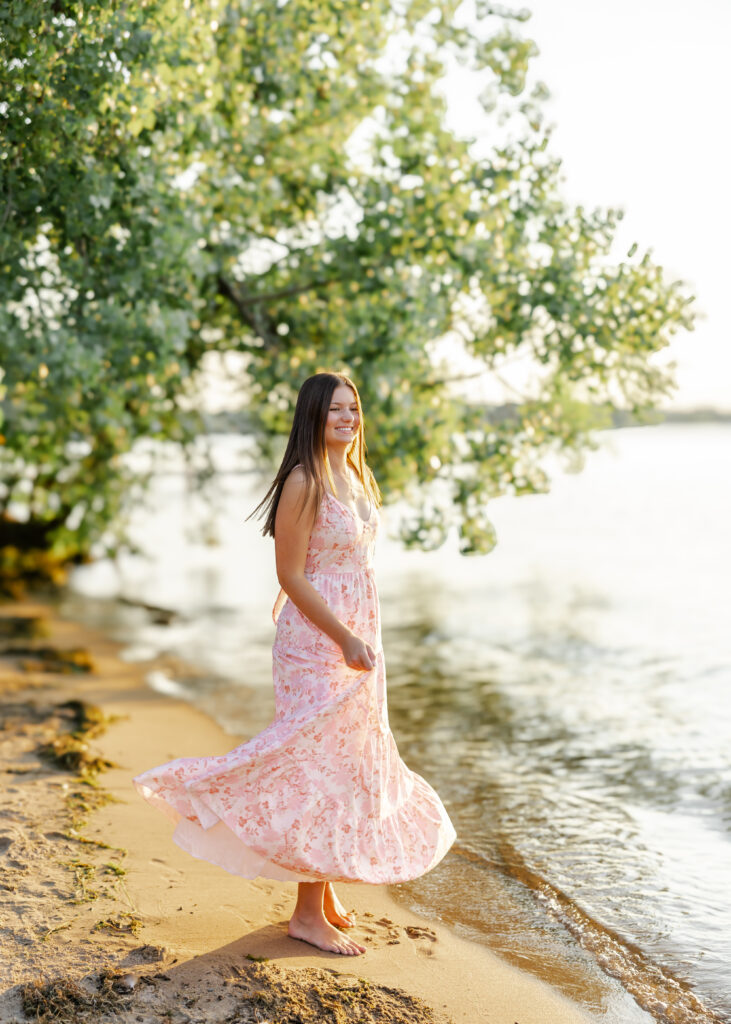 Girl runs along Excelsior beach in white and pink flowy dress for her eden prairie senior pictures with senior photographer angela watts photography.