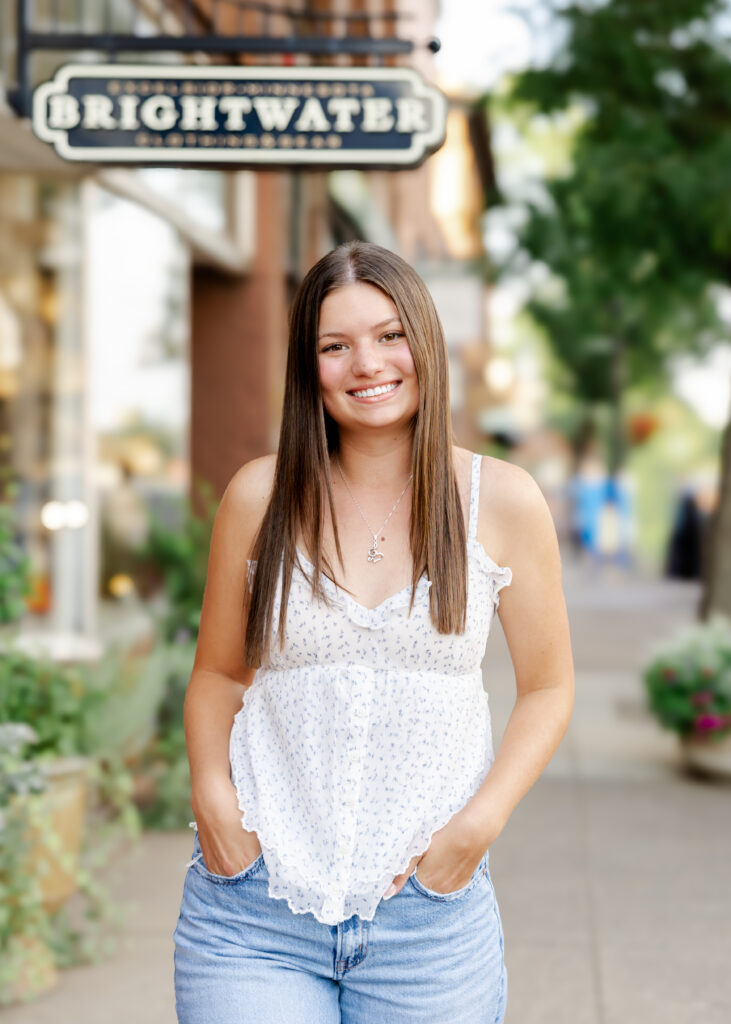 Girl in jeans and white tank takes her eden prairie senior photos downtown excelsior with senior photographer angela watts photography