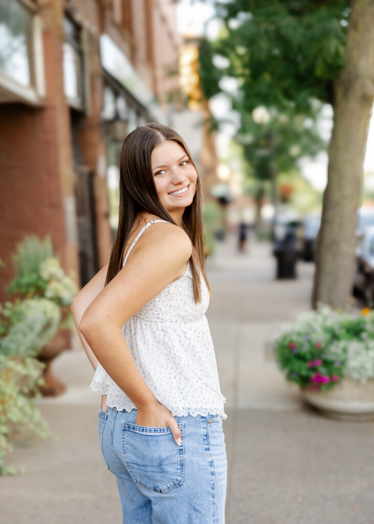 Girl in jeans and white tank takes her eden prairie senior photos downtown excelsior with senior photographer angela watts photography