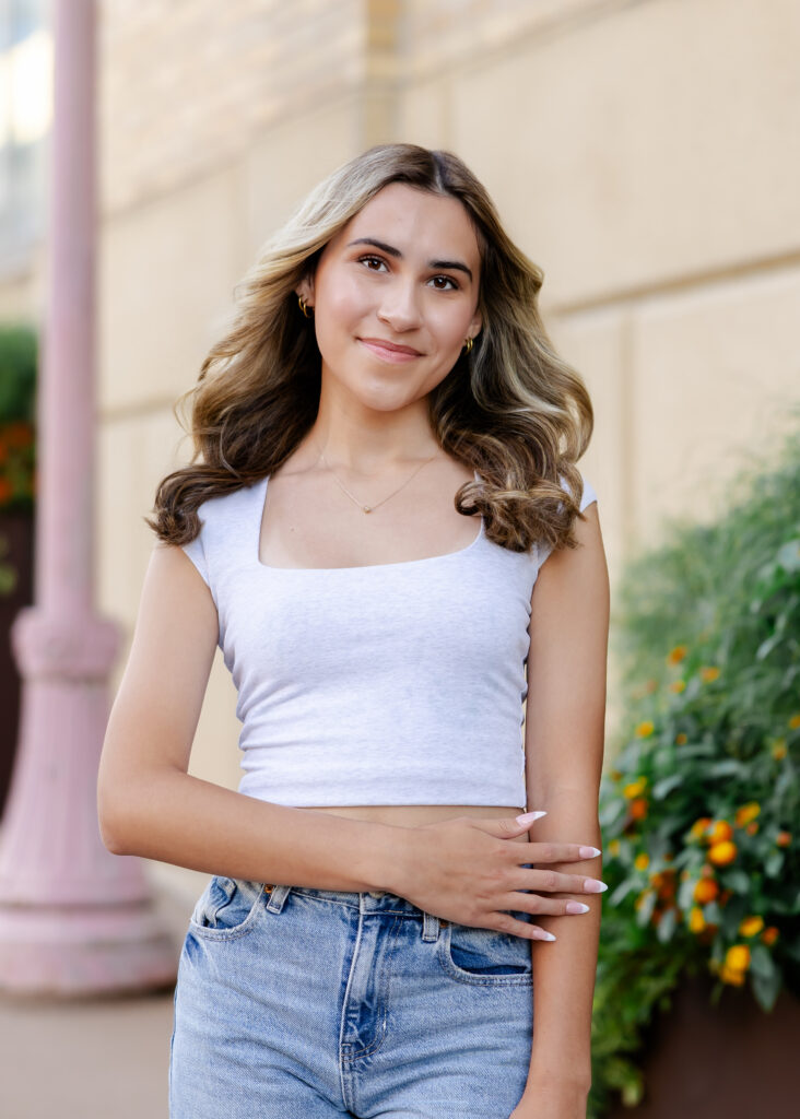 Wayzata high school senior poses at mill ruins park for her wayzata senior pictures with angela watts photography