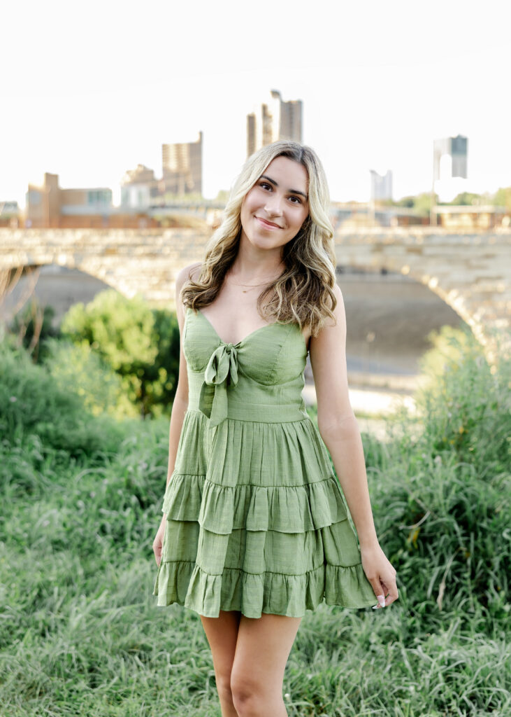 Wayzata high school senior poses at mill ruins park for her wayzata senior pictures with angela watts photography