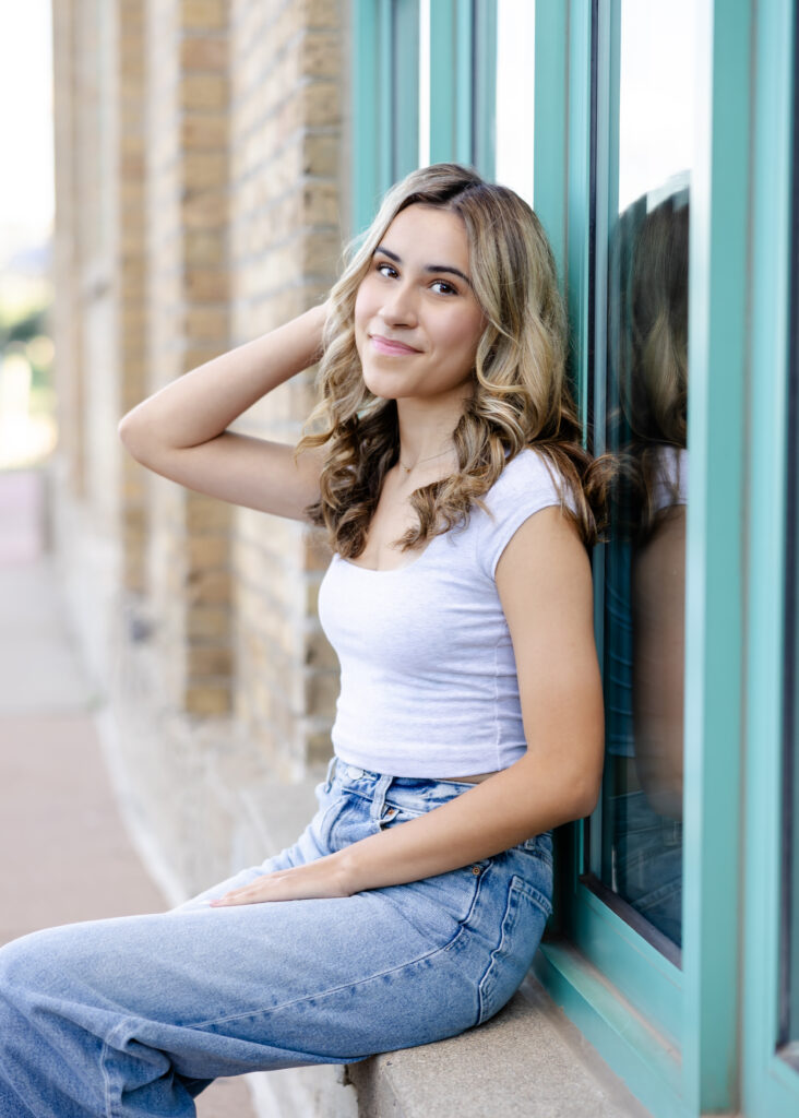 Wayzata high school senior poses at mill ruins park for her wayzata senior pictures with angela watts photography
