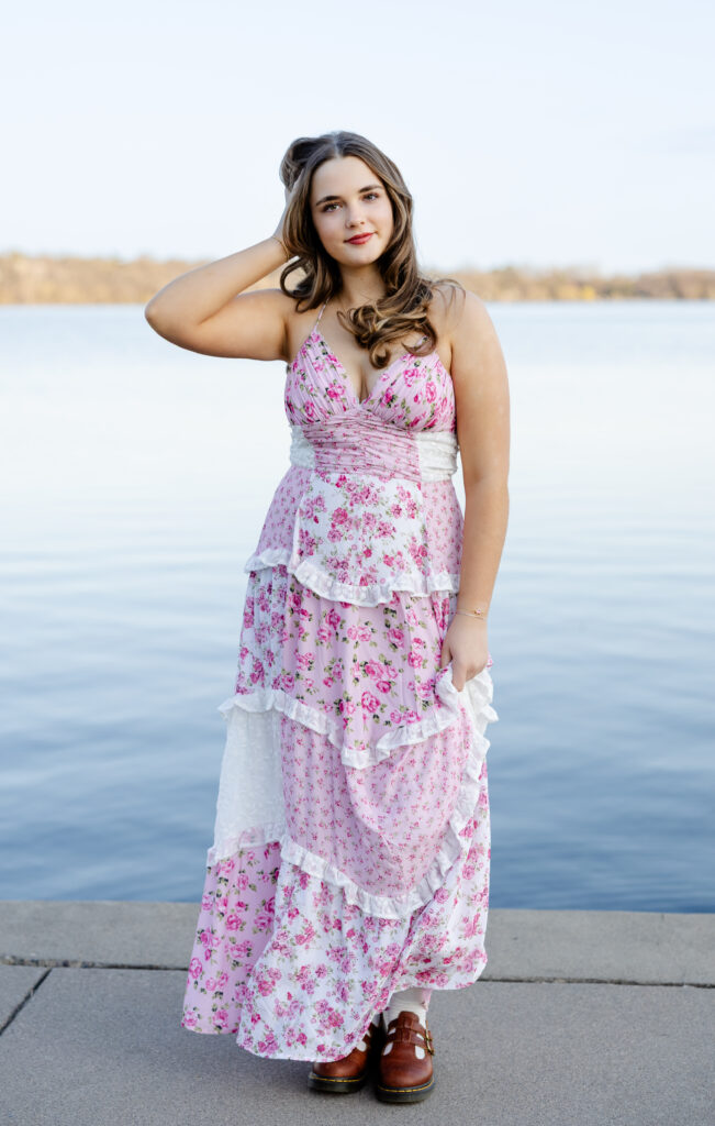 girl in pink dress poses at lake harriet for her minneapolis senior photos with angela watts photography