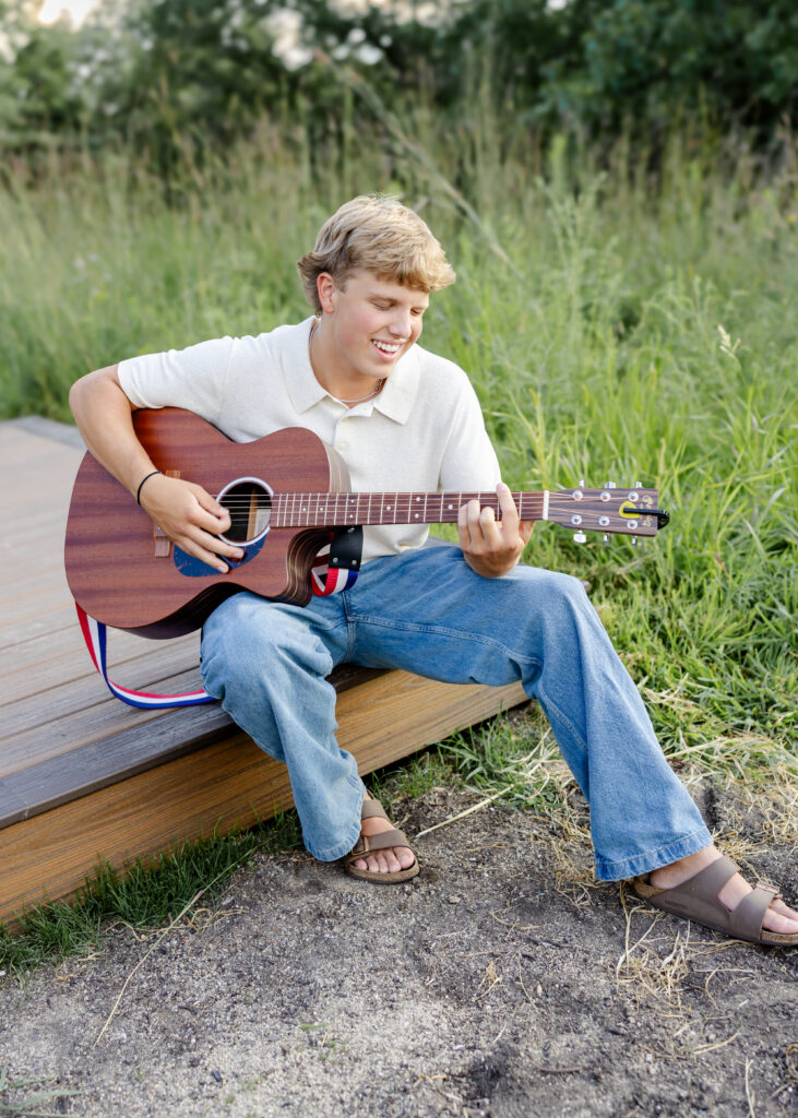 boy sings and plays guitar at richardson nature center for his minneapolis senior pictures