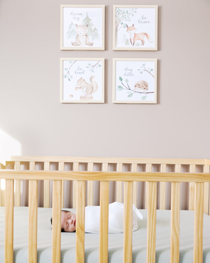 newborn baby sleeps in his crib during his edina, minnesota newborn photography session with angela watts photography.