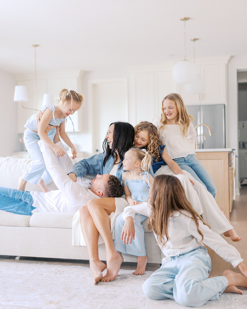 family of 7 play on their minneapolis sofa during their in-home minneapolis family photography session with angela watts