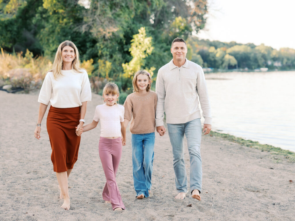 family of 4 walk on a beach at west medicine lake park in plymouth, minnesota for their minneapolis family photos with angela watts