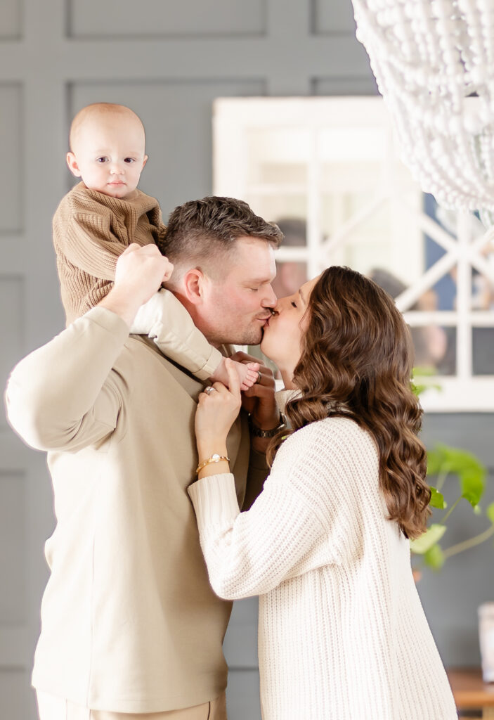 mom dad and 8 month old baby stand in their living room during their edina family photography session