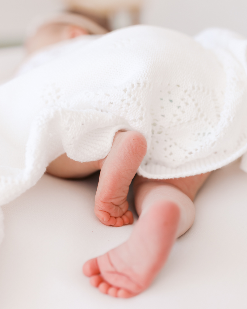 Tiny feet and toes of a newborn baby girl captured in detail during her minneapolis newborn photoshoot with angela watts.