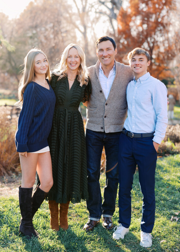 family of 4 with 2 teens pose at lake harriet peace garden for their minneapolis family photography session with angela watts photography