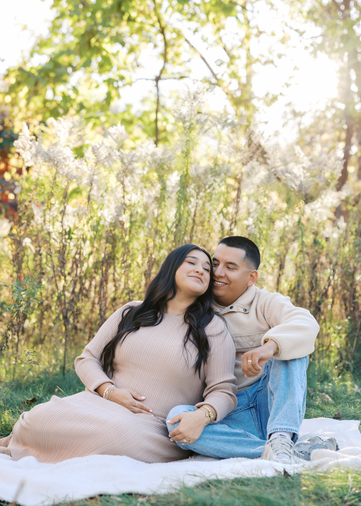 husband and wife hold hands at longfellow gardens in minneapolis for their maternity photography session