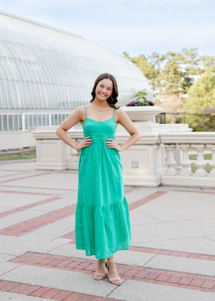 girl in long yellow dress poses at como park conservatory for her minneapolis senior pictures photography session