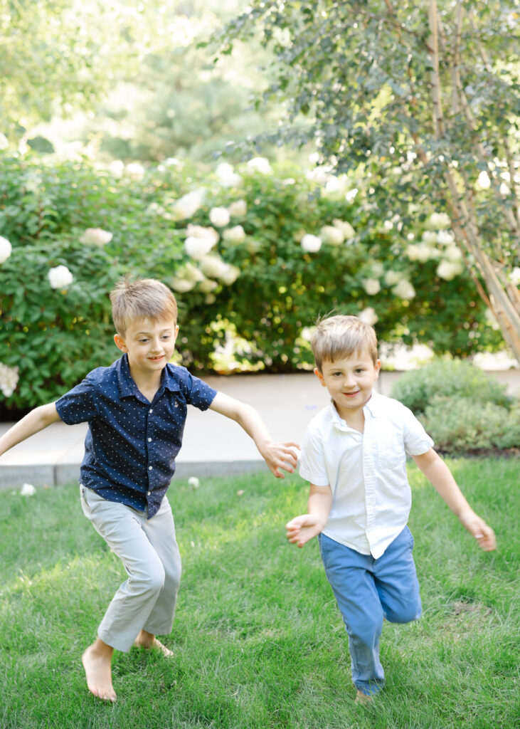 2 young brothers young in their front yard of their linden hills, minneapolis home for their minneapolis family photography session with angela watts