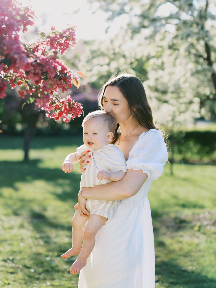 mom kisses baby on forehead at lyndale park gardens for their minneapolis family photos